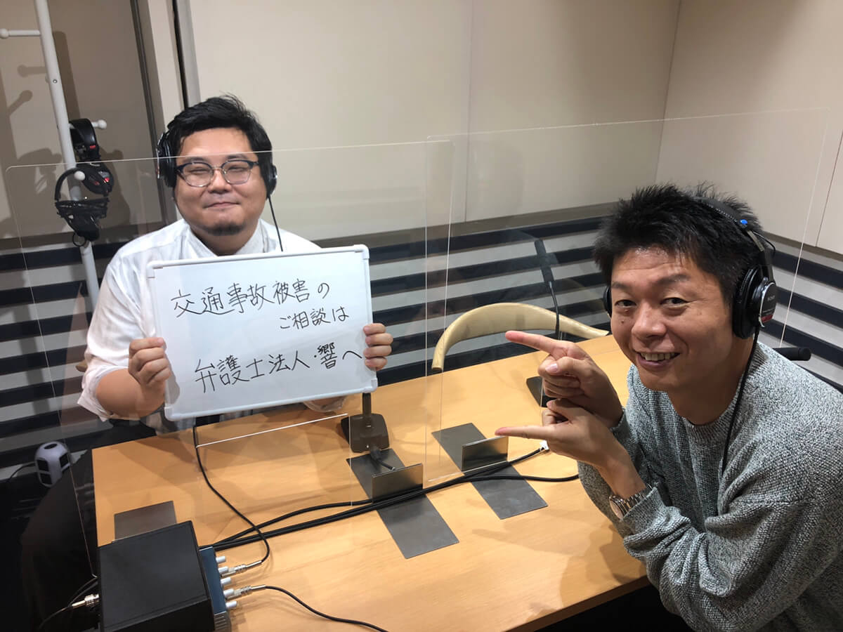交通事故のご相談は弁護士法人・響へと書かれたボードを持つ島田秀平さんと澁谷望弁護士