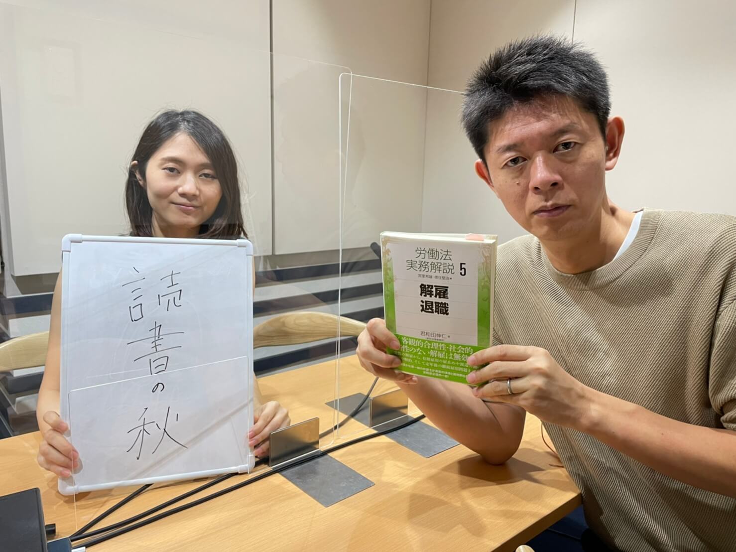 読書の秋と書かれたボードを持った古藤由佳弁護士と労働法解説書を持った島田秀平さん