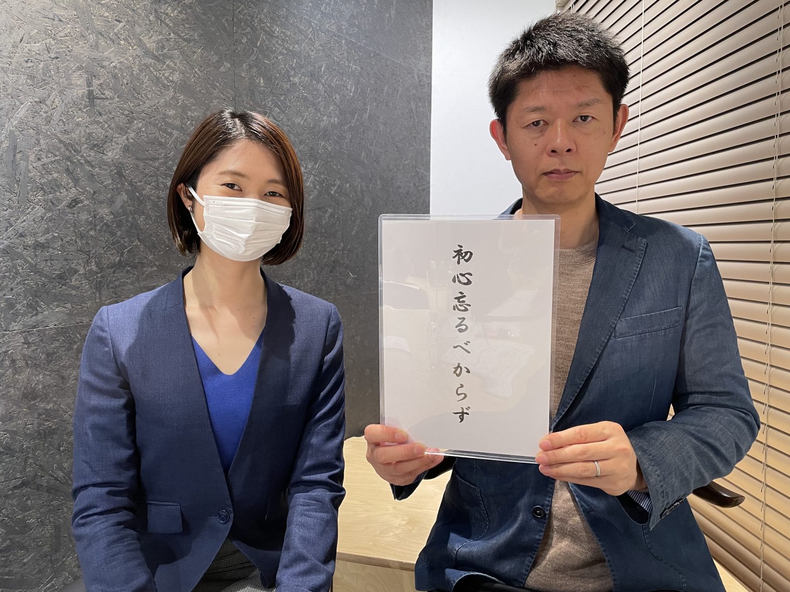 「初心忘るべからず」と書いた紙を持つ島田秀平さんと古藤由佳弁護士