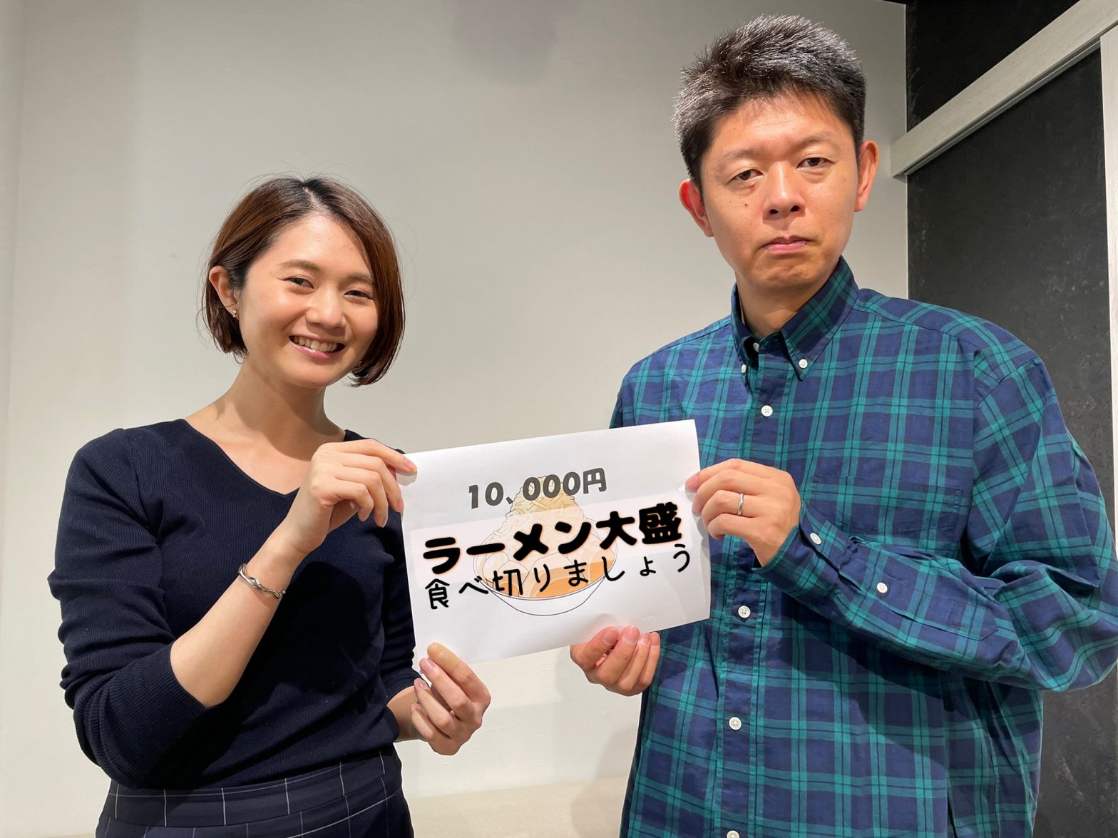 「ラーメン大盛食べ切りましょう」と書かれた紙を持った島田秀平さんと古藤由佳弁護士